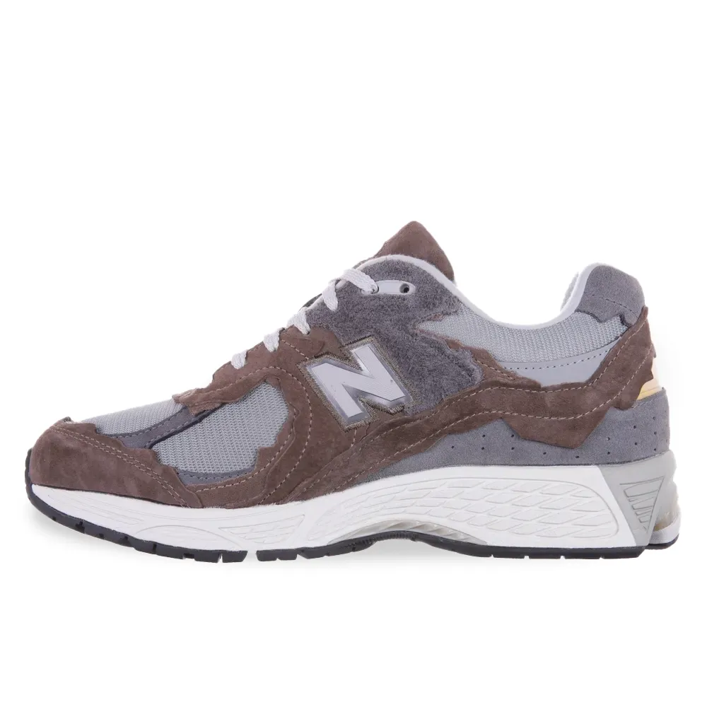Tênis New Balance 2002d Masculino Marrom em ângulo lateral destacando o logo 'N' e materiais do cabedal.